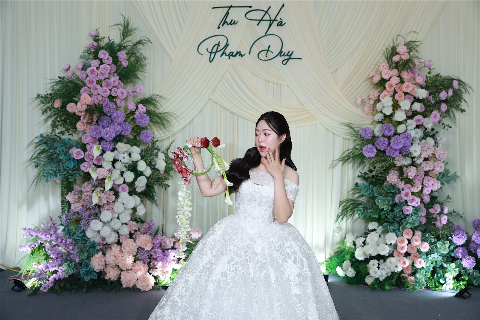Cô dâu tạo dáng tại backdrop hoa của HM Photobooth trong tiệc cưới